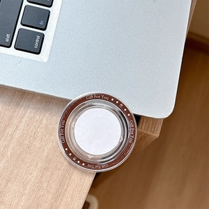 Detail of round MagSafe phone stand in Gift For You gift box on office desk surface