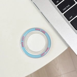 Detail of a transparent MagSafe phone socket cap with pink Good Luck text and blue border
