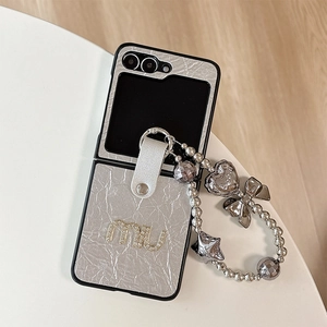 Gros plan sur la coque en cuir argenté avec lettres en strass et cordon à perles décoratif