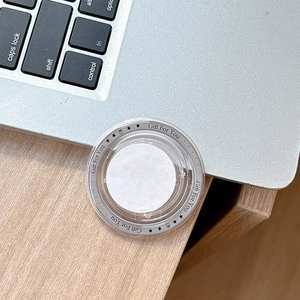 Detail of round transparent MagSafe phone socket with Gift For You print on laptop