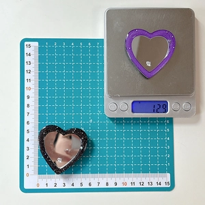 Macro detail showing heart-shaped resin glitter mirror measuring 5cm and 12.9g weight