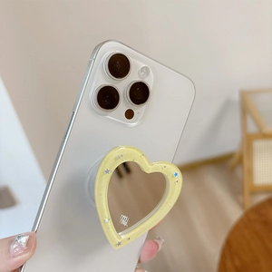 Close-up of glitter heart phone grip with mirror and star sequins on a white phone