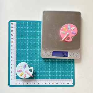 Detailed view of mini paint palette phone stand showing dimensions on a scale and grid