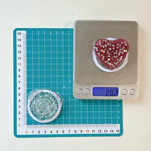 Glitter heart phone socket grip showing weight of 20.2g on digital scale measurement