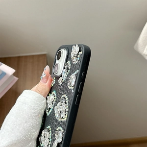 Detailed close-up of a luxury black snakeskin case with sparkling heart-shaped rhinestones