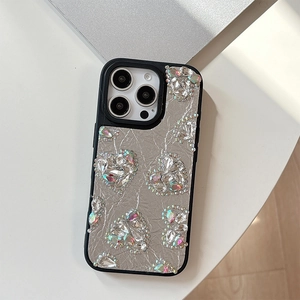 Detailed view of silver leather phone case with colorful rhinestone heart patterns