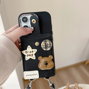 Detail der schwarzen iPhone-Hülle mit Bär, Stern-Patch und Karo-Button-Geldbörse