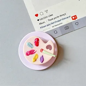 Detailed close-up of a mini 3D artist palette phone grip with tiny paintbrush detail