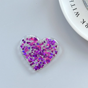 Macro shot of heart-shaped glitter phone grip with purple sequins and acrylic finish