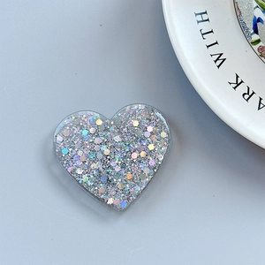 Macro view of heart-shaped phone grip with iridescent silver sequins and glitter
