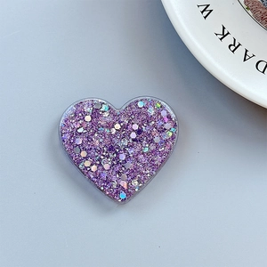 Detail of purple glitter heart phone grip with sparkling laser sequins on a blue background