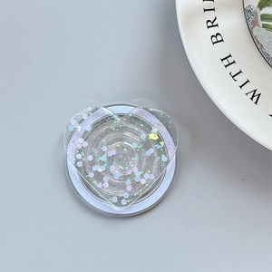 Macro detail of transparent heart-shaped phone grip with colorful sequins and white base