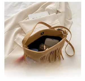 Detail view of suede fringe bag interior showing storage space and magnetic buckle