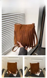Detailed view of a brown frosted leather bucket bag with long bohemian fringe tassels