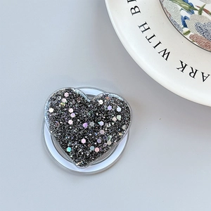 Detail of heart phone grip with black glitter and colorful sequins in macro view