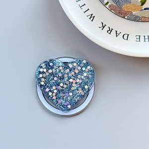 Detail shot of heart-shaped phone grip with blue glitter sequins and blue expander base