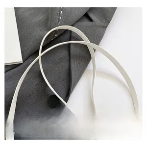 Détail d'une bandoulière en cuir blanc grainé avec crochets métalliques dorés
