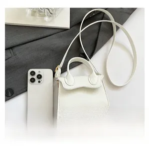 Mini sac à main blanc en cuir grainé avec un smartphone pour référence de taille
