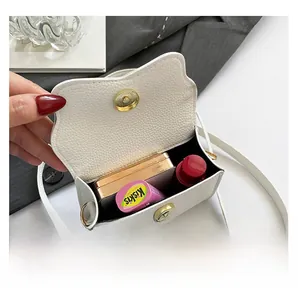 Vue intérieure du mini sac blanc grainé montrant la capacité pour rouge à lèvres