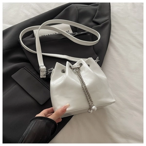Detail der weißen Beuteltasche mit Kordelzug und dekorativem Perlenketten-Akzent
