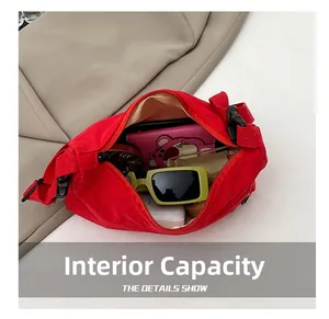 Detail view showing interior capacity of red canvas crossbody bag with everyday items