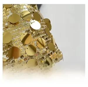 Macro shot of shimmering gold sequins on textured fabric for this stylish handbag