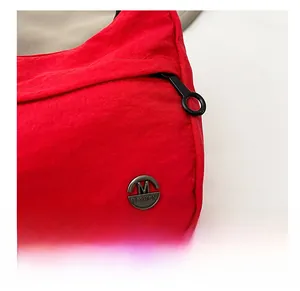 Macro detail of red nylon fabric with black M FASHION logo and high-quality metal zipper