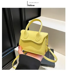 Vue détaillée d'un sac à main jaune en cuir grainé avec rabat ondulé et poignée