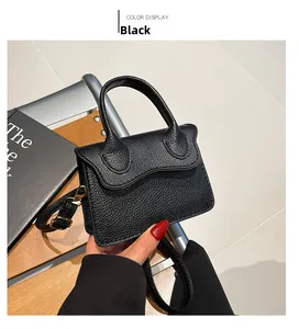 Gros plan sur la texture grainée noire et le fermoir en métal doré du sac à main
