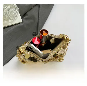 Macro view of interior capacity of sequined handbag with gold chain and cosmetics