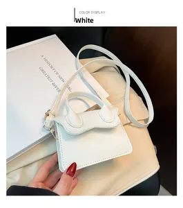 Détail du mini sac à main blanc motif litchi avec accessoires dorés et bandoulière