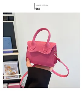 Vue détaillée du mini sac bandoulière rose avec rabat à bords ondulés et cuir grainé