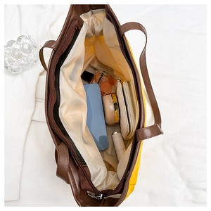 Vue de dessus de l'intérieur spacieux du grand sac fourre-tout jaune avec accessoires