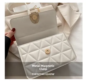 Détail du sac à rabat matelassé blanc avec fermoir magnétique doré et bandoulière