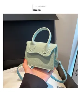 Détail de la texture cuir vert à motif litchi sur un mini sac à main carré tendance