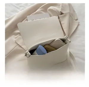 Interior storage capacity showing daily essentials in a sleek cream flap shoulder bag