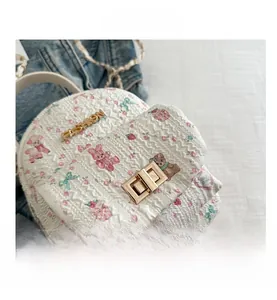 Detail of white quilted handbag with floral bunny prints and golden fashion clasp