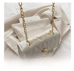 Détail du sac bandoulière blanc matelassé avec chaîne dorée et fermoir rotatif rond