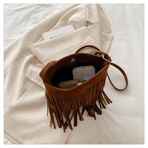 Interior view of brown suede tassel handbag with magnetic snap and daily essentials