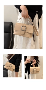 Close-up of minimalist beige leather handbag with silver metal buckle and dual straps