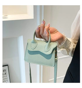 Détail du mini sac à main vert menthe avec texture litchi et ferrures métalliques
