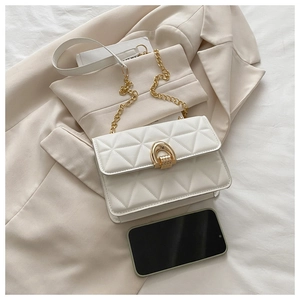 Detailansicht der weißen Stepptasche mit goldenem Verschluss und eleganter Kettenriemen
