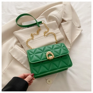 Détail du sac bandoulière matelassé vert avec fermoir fer à cheval doré et chaîne