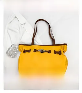 Vue détaillée du sac cabas en nylon jaune avec lanières en simili cuir brun et boucle