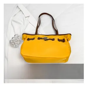 Détail d'un sac à bandoulière bicolore avec boucle en métal et smartphone pour échelle de taille