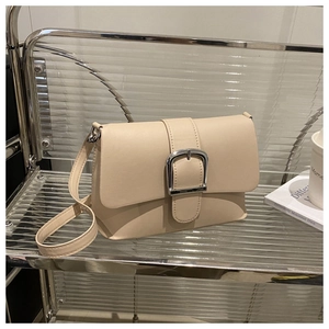 Detail view of beige retro crossbody bag featuring a large silver square metal buckle