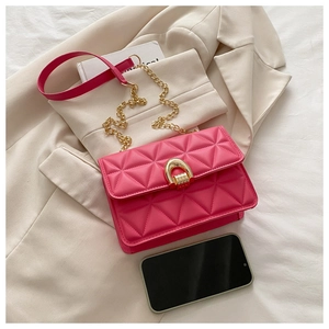 Detail of hot pink quilted crossbody bag with golden chain and stylish U-shaped metal lock