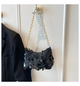 Détail du sac sous le bras à paillettes noires avec texture brillante et chaîne dorée