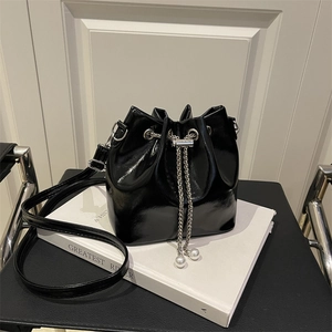 Schwarze Lackleder-Beuteltasche mit silberner Kette, Kordelzug und Perlendetails