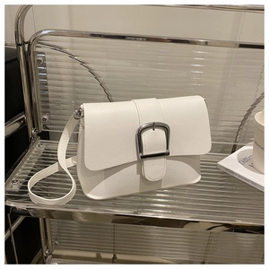 Close-up of white leather handbag featuring a large silver square buckle and sleek flap